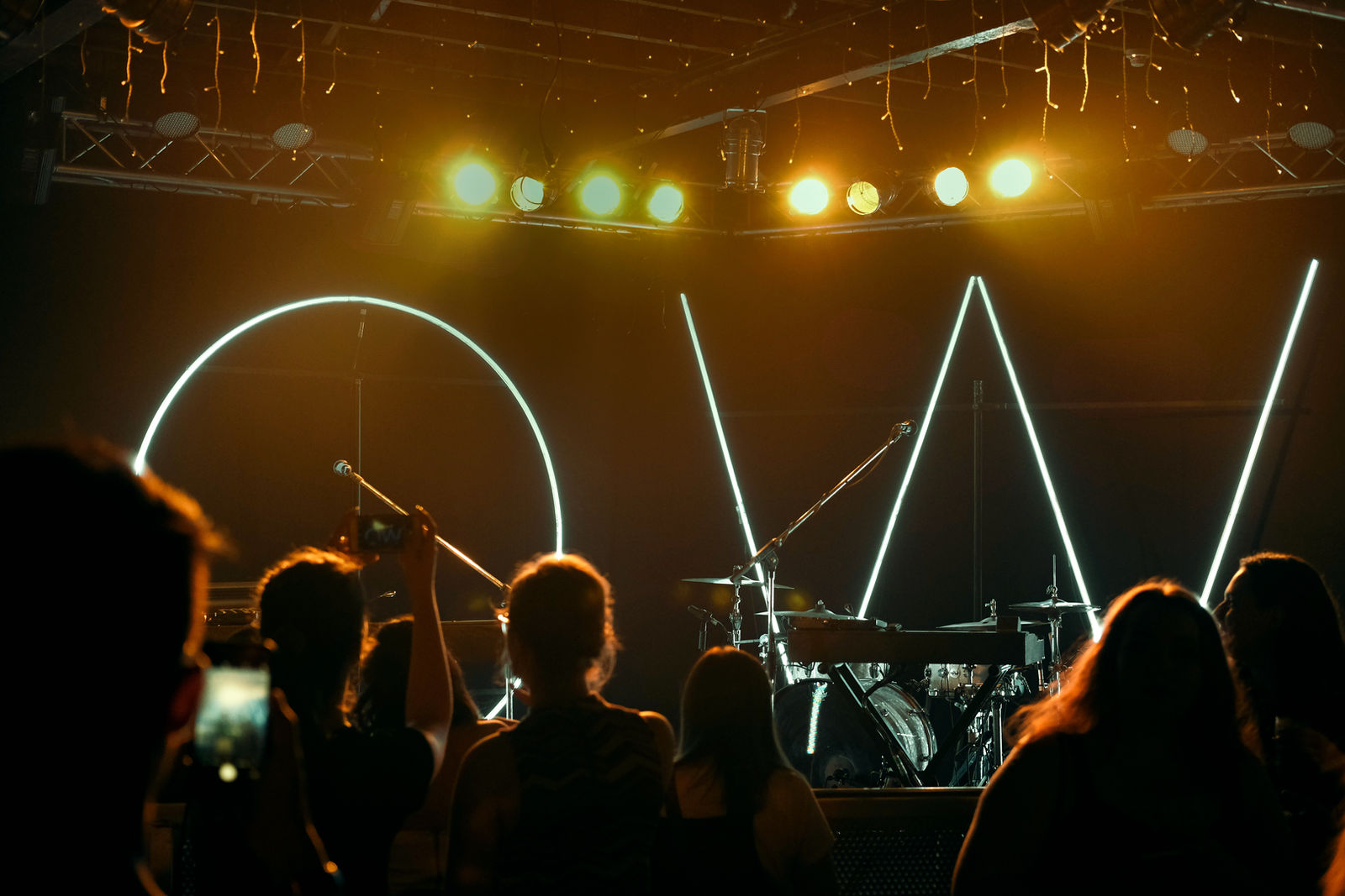 A crowd facing a lit stage at a live show